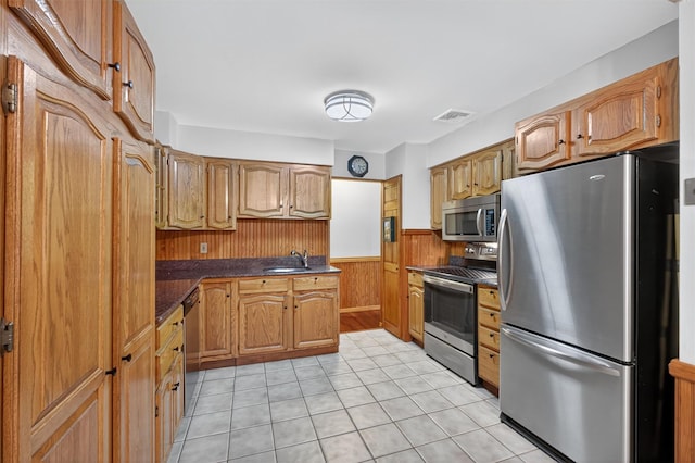 69 Crafts Rd, Carmel, NY 10512 - kitchen with appliances with stainless steel finishes, dark countertops, a wainscoted wall, light tile patterned floors, and wooden walls