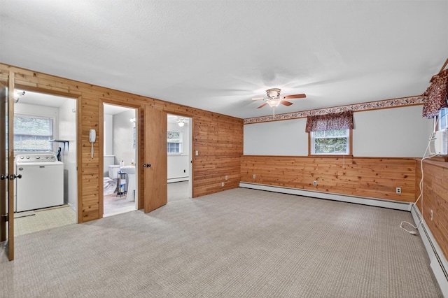 69 Crafts Rd, Carmel, NY 10512 - unfurnished room featuring washer / dryer, wooden walls, a baseboard heating unit, a ceiling fan, and plenty of natural light