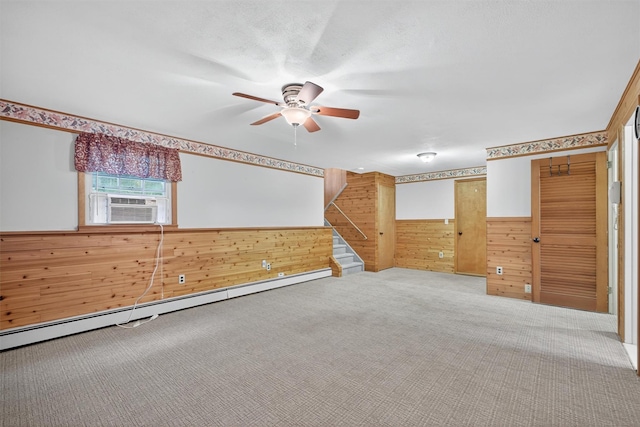 69 Crafts Rd, Carmel, NY 10512 - carpeted spare room featuring wooden walls, ceiling fan, stairs, a wainscoted wall, and baseboard heating