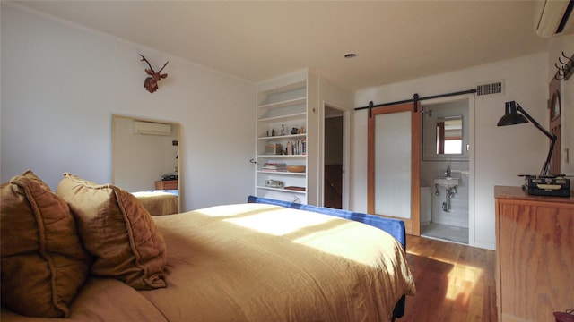 1651 201st St, Bayside, NY 11360 - bedroom featuring a wall mounted AC, wood finished floors, a barn door, and ensuite bath