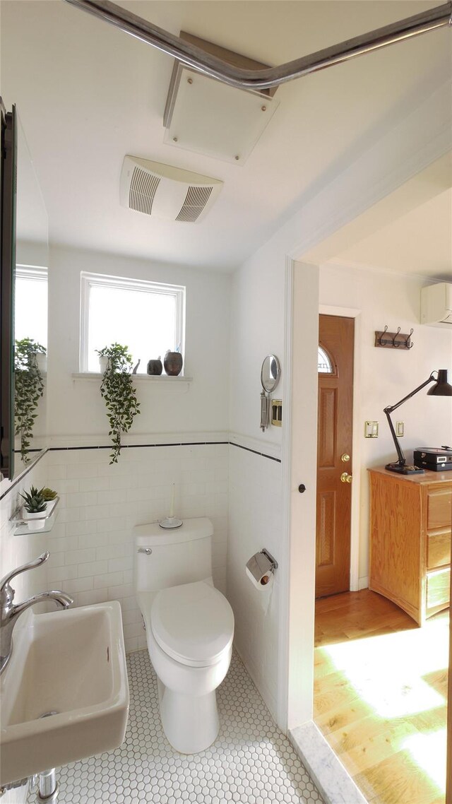1651 201st St, Bayside, NY 11360 - bathroom with a sink, an AC wall unit, toilet, tile patterned floors, and tile walls