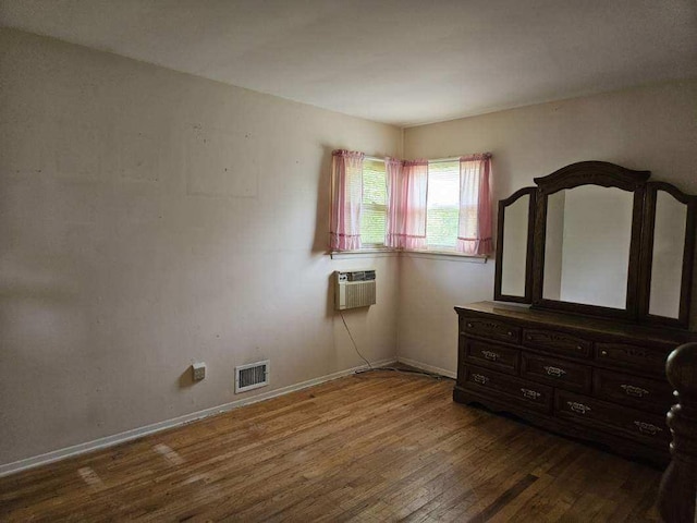 209 Loop Dr, Sayville, NY 11782 - unfurnished bedroom with wood finished floors and a wall mounted air conditioner