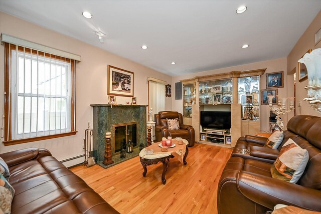 4539 192nd St, Flushing, NY 11358 - living room with wood finished floors, a high end fireplace, a baseboard radiator, and recessed lighting