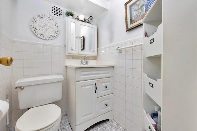99-40 63rd Rd Unit 9Z, Rego Park, NY 11374 - bathroom featuring tile walls, tile patterned floors, a wainscoted wall, toilet, and vanity