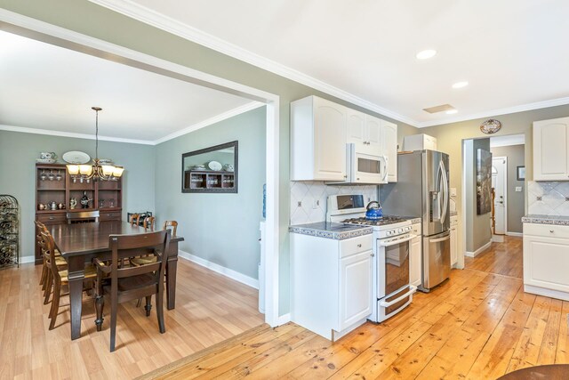 7 Dawn Dr, East Northport, NY 11731 - kitchen with white appliances, white cabinets, light wood-style floors, crown molding, and recessed lighting
