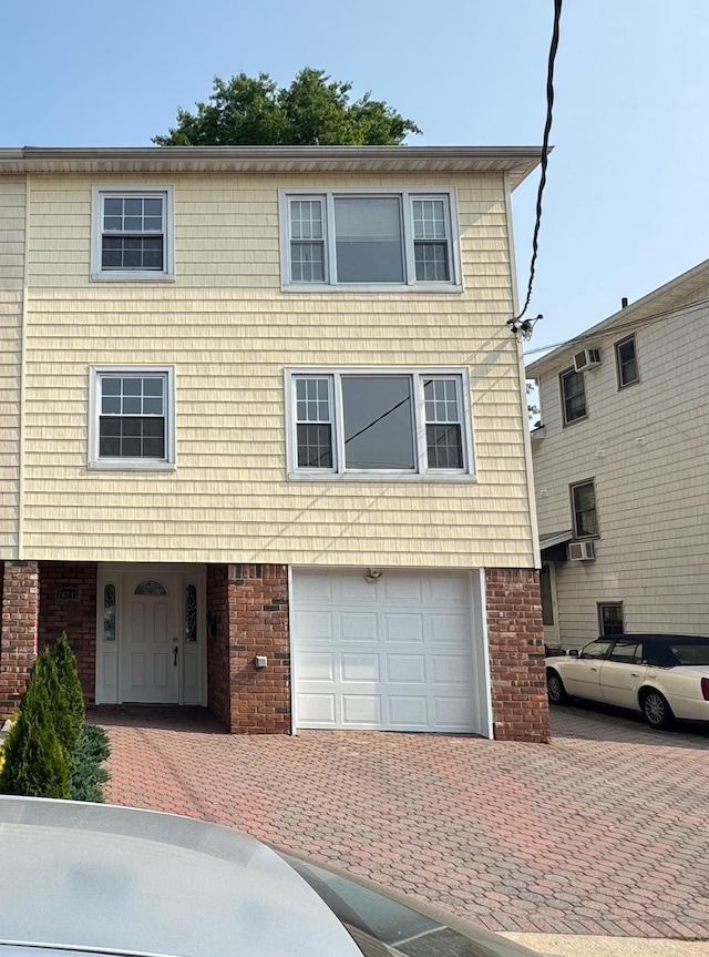 20817 15th Rd, Bayside, NY 11360 - view of front of property featuring an attached garage, decorative driveway, brick siding, and cooling unit