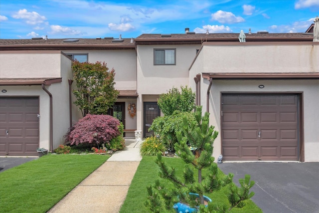1 Anchorage Way Unit 704, Freeport, NY 11520 - view of property featuring stucco siding, a garage, and asphalt driveway