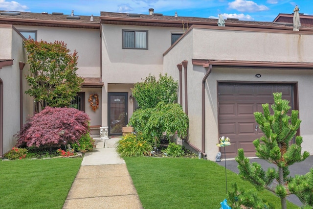1 Anchorage Way Unit 704, Freeport, NY 11520 - view of front facade featuring a front yard, a garage, and stucco siding