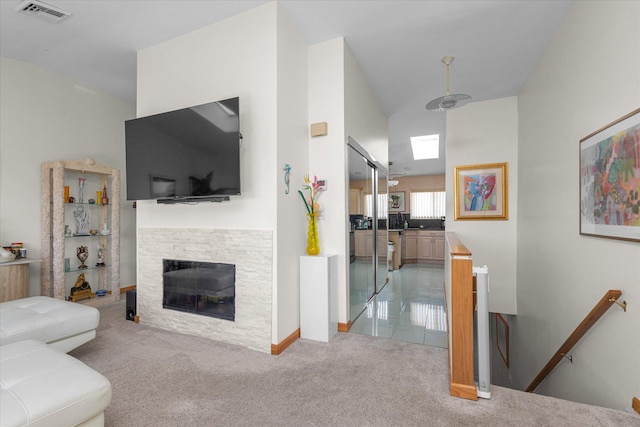 1 Anchorage Way Unit 704, Freeport, NY 11520 - living area with light colored carpet, a stone fireplace, and lofted ceiling
