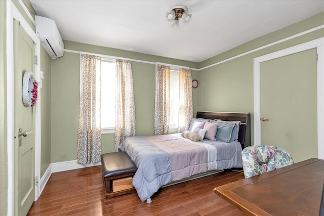 48-46 206th St Unit 2, Bayside, NY 11364 - bedroom with a wall mounted air conditioner, wood finished floors, and baseboards