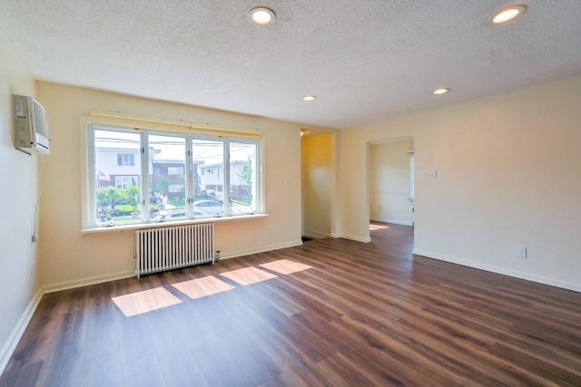 162-29 95th St, Howard Beach, NY 11414 - empty room with radiator, dark wood finished floors, a wall mounted AC, a textured ceiling, and recessed lighting