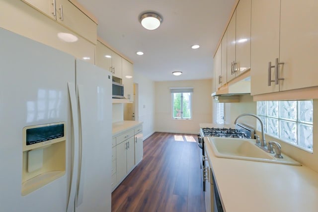 162-29 95th St, Howard Beach, NY 11414 - kitchen with white refrigerator with ice dispenser, under cabinet range hood, light countertops, dark wood-type flooring, and recessed lighting