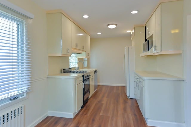 162-29 95th St, Howard Beach, NY 11414 - kitchen featuring radiator heating unit, freestanding refrigerator, gas stove, wood finished floors, and light countertops