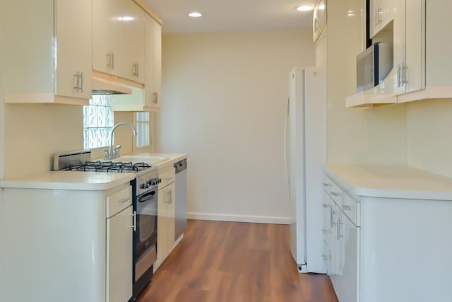 162-29 95th St, Howard Beach, NY 11414 - kitchen featuring stainless steel appliances, under cabinet range hood, dark wood-style floors, light countertops, and recessed lighting