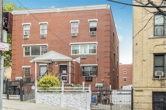 1321 Lafayette Ave, Bronx, NY 10474 - townhome / multi-family property featuring brick siding, a gate, a fenced front yard, and cooling unit