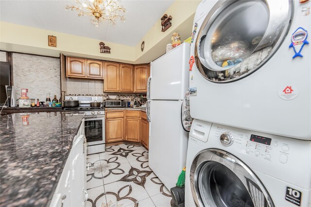 1321 Lafayette Ave, Bronx, NY 10474 - washroom featuring estacked washer and dryer, light tile patterned flooring, and a chandelier