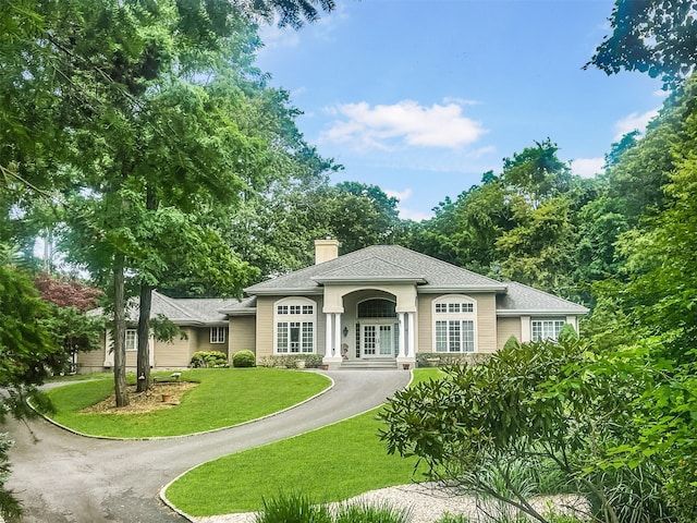 91 Harbor Rd, Head Of The Harbor, NY 11780 - view of front of house featuring a front yard, a chimney, a shingled roof, and asphalt driveway
