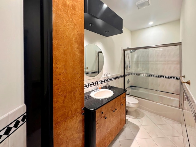 91 Harbor Rd, Head Of The Harbor, NY 11780 - bathroom with toilet, tile patterned floors, tile walls, vanity, and combined bath / shower with glass door