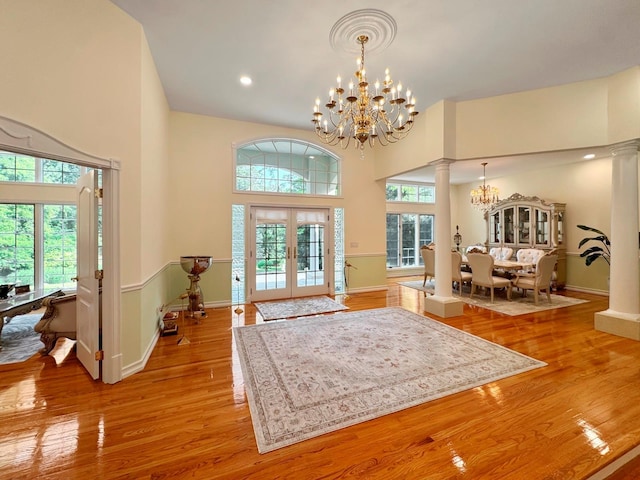 91 Harbor Rd, Head Of The Harbor, NY 11780 - entryway with a chandelier, decorative columns, light wood-type flooring, a high ceiling, and baseboards