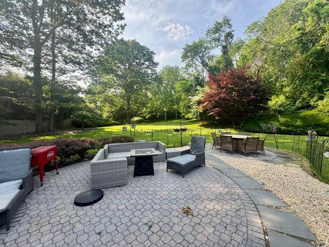 91 Harbor Rd, Head Of The Harbor, NY 11780 - view of patio / terrace with view of scattered trees, outdoor dining space, and an outdoor living space with a fire pit
