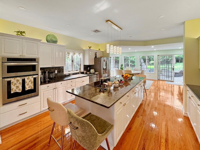 91 Harbor Rd, Head Of The Harbor, NY 11780 - kitchen with stainless steel appliances, dark countertops, light wood-style floors, white cabinets, and recessed lighting