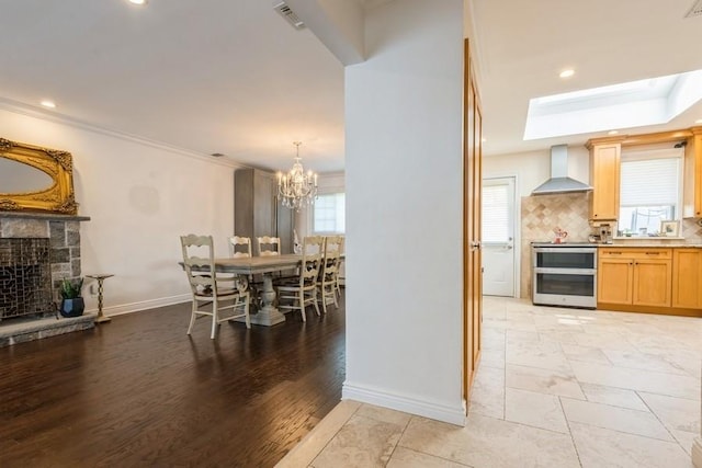 696 Byron Ave, Franklin Square, NY 11010 - dining room featuring baseboards, a fireplace, a chandelier, a skylight, and recessed lighting