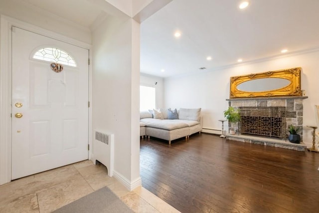 696 Byron Ave, Franklin Square, NY 11010 - foyer entrance with radiator, baseboard heating, a stone fireplace, recessed lighting, and wood finished floors