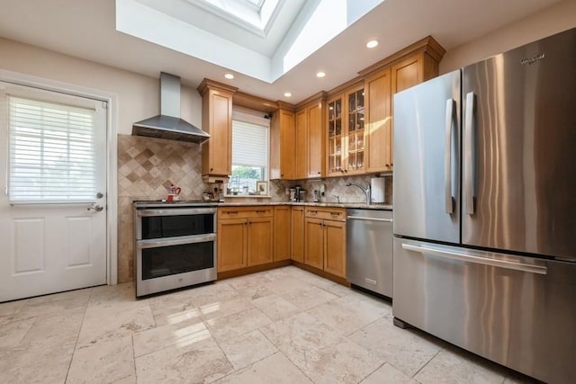 696 Byron Ave, Franklin Square, NY 11010 - kitchen with stainless steel appliances, wall chimney range hood, tasteful backsplash, a skylight, and recessed lighting