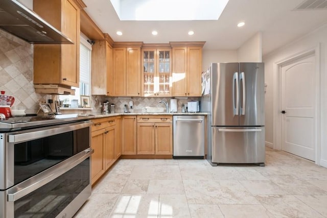 696 Byron Ave, Franklin Square, NY 11010 - kitchen featuring appliances with stainless steel finishes, wall chimney range hood, a skylight, backsplash, and a sink