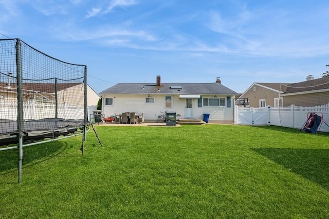 696 Byron Ave, Franklin Square, NY 11010 - back of house featuring a trampoline, a patio, and a gate