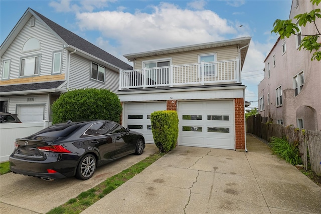 721 E Walnut St, Long Beach, NY 11561 - view of front of home with concrete driveway, an attached garage, a balcony, and brick siding