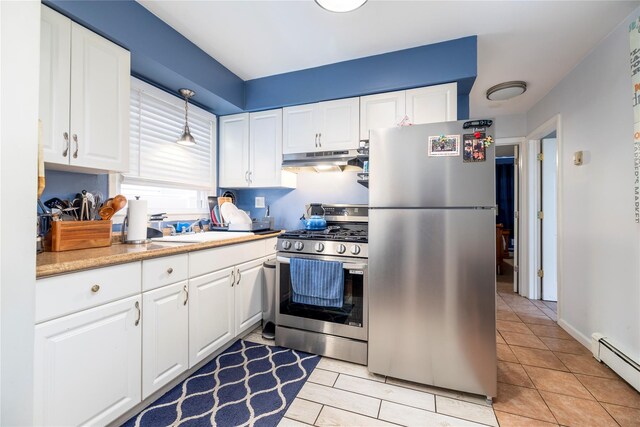 721 E Walnut St, Long Beach, NY 11561 - kitchen with stainless steel appliances, baseboard heating, under cabinet range hood, white cabinets, and light countertops