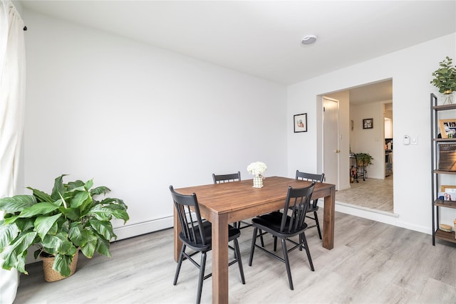 721 E Walnut St, Long Beach, NY 11561 - dining area featuring light wood finished floors, baseboards, and a baseboard heating unit