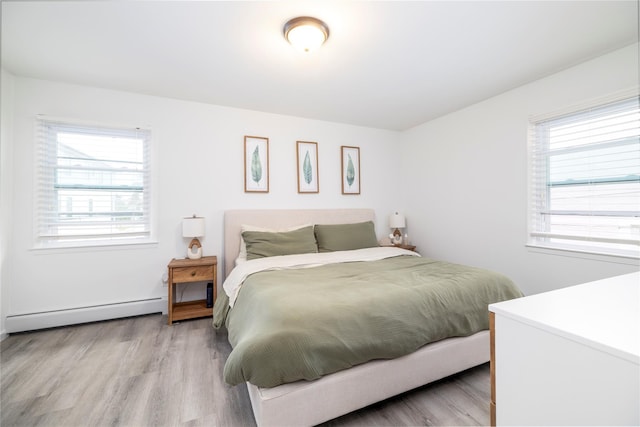 721 E Walnut St, Long Beach, NY 11561 - bedroom with baseboard heating, multiple windows, and light wood-style floors