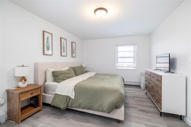 721 E Walnut St, Long Beach, NY 11561 - bedroom with a baseboard heating unit, light wood finished floors, and baseboards