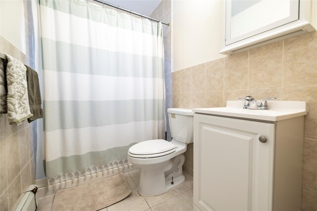 721 E Walnut St, Long Beach, NY 11561 - full bathroom featuring tile walls, baseboard heating, toilet, vanity, and tile patterned floors