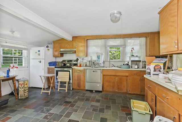 3868 Indian Hill Rd, Shrub Oak, NY 10588 - kitchen featuring appliances with stainless steel finishes, under cabinet range hood, light countertops, brown cabinets, and dark stone finish flooring