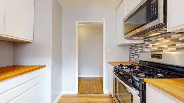 65-35 108th St Unit D7, Forest Hills, NY 11375 - kitchen with appliances with stainless steel finishes, wood counters, white cabinets, and backsplash