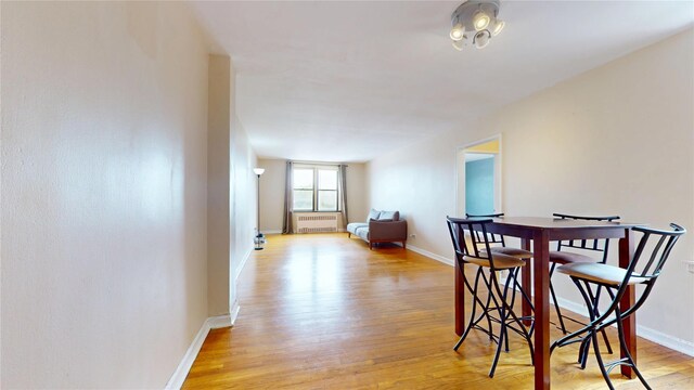 65-35 108th St Unit D7, Forest Hills, NY 11375 - dining space featuring radiator, light wood-style floors, and baseboards
