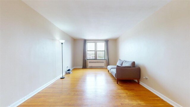 65-35 108th St Unit D7, Forest Hills, NY 11375 - living area with radiator, light wood-type flooring, and baseboards