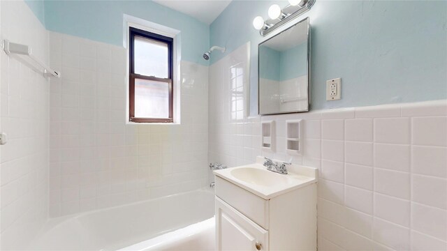 65-35 108th St Unit D7, Forest Hills, NY 11375 - full bathroom with vanity, washtub / shower combination, tile walls, and a wainscoted wall