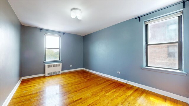 65-35 108th St Unit D7, Forest Hills, NY 11375 - empty room with radiator, light wood finished floors, and baseboards
