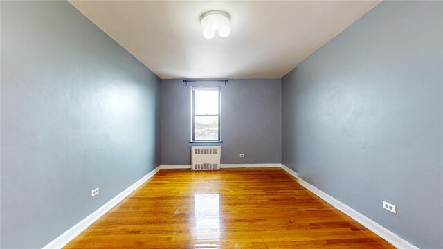 65-35 108th St Unit D7, Forest Hills, NY 11375 - empty room featuring radiator, light wood finished floors, and baseboards