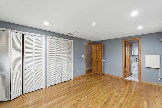 73 Fox Pl, Hicksville, NY 11801 - unfurnished bedroom with multiple closets, light wood-style flooring, baseboards, recessed lighting, and ensuite bathroom
