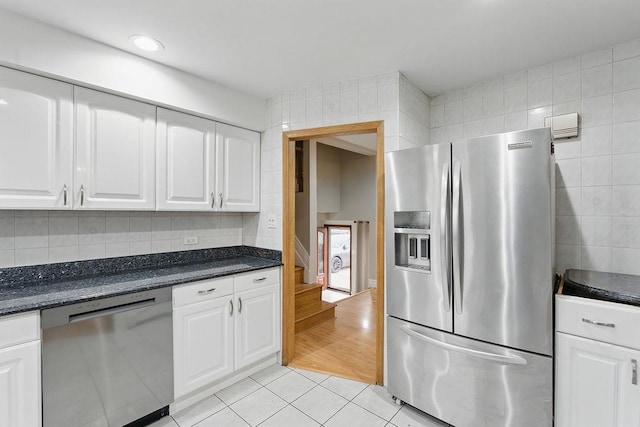 73 Fox Pl, Hicksville, NY 11801 - kitchen with stainless steel appliances, light tile patterned flooring, white cabinetry, decorative backsplash, and tile walls