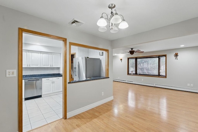 73 Fox Pl, Hicksville, NY 11801 - empty room featuring a chandelier, baseboard heating, light wood-style floors, a ceiling fan, and baseboards