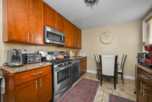 211-40 18th Ave Unit 4A, Bayside, NY 11360 - kitchen with stainless steel appliances, light stone counters, tasteful backsplash, and brown cabinets