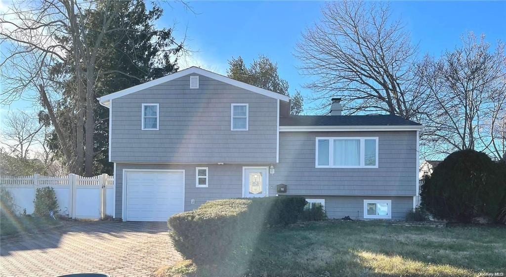 28 Speed St, Brentwood, NY 11717 - rear view of property with an attached garage and decorative driveway