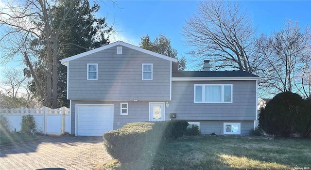 28 Speed St, Brentwood, NY 11717 - rear view of property with an attached garage and decorative driveway