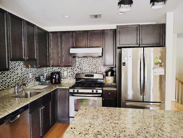 2-18A Constitution Pl Unit 173, College Point, NY 11356 - kitchen featuring appliances with stainless steel finishes, under cabinet range hood, a sink, light stone countertops, and decorative backsplash